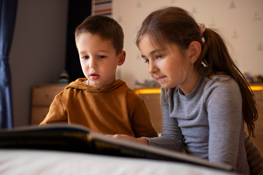 Niños observando y leyendo juntos un libro
